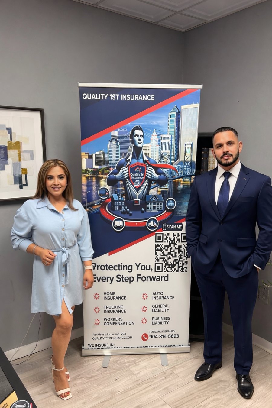 The Quality 1st Insurance team standing beside their branded banner in the Jacksonville office